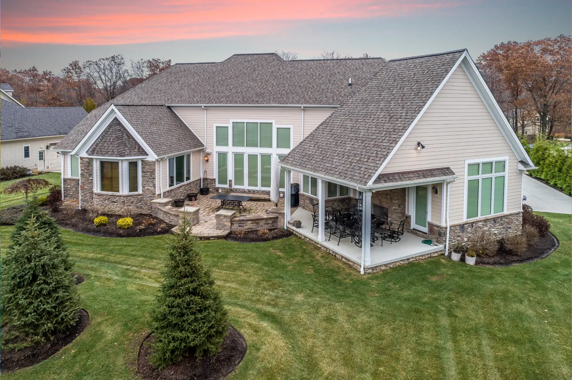 A large house with a patio and lawn in it